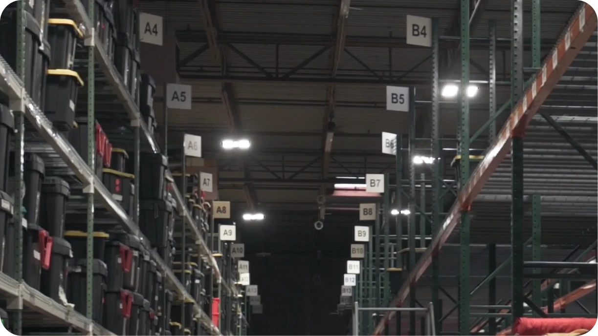 Warehouse aisle end cap labels showing location codes for event rental inventory